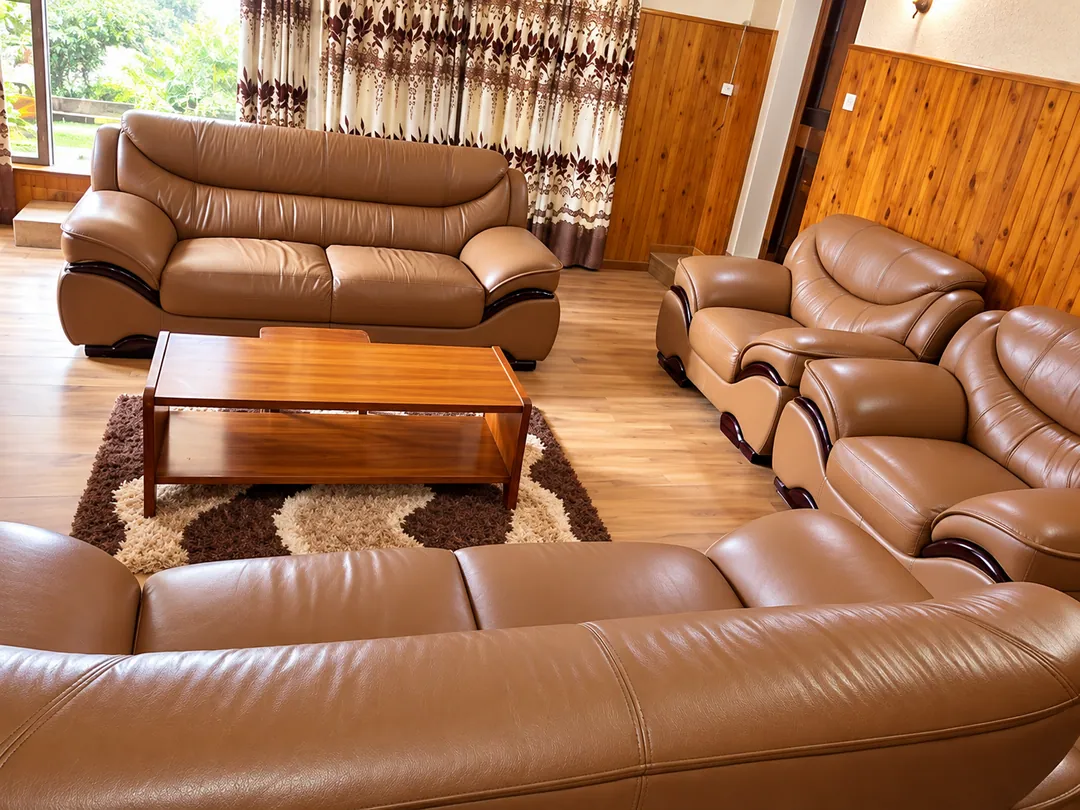 Wood-panelled lounge with caramel leather sofas, a timber coffee table and a patterned rug
